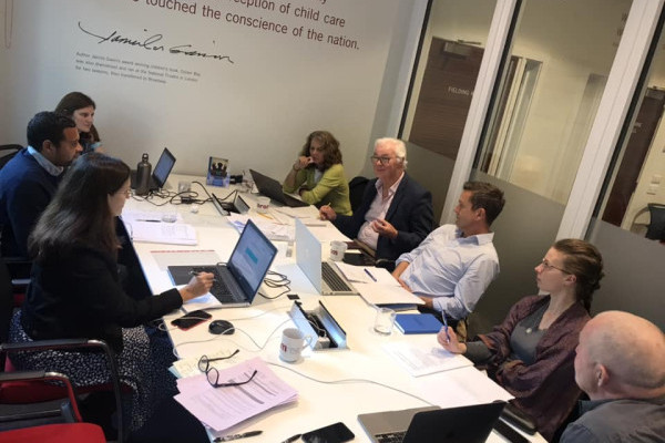 A team of people around a large table, sharing thoughts and collaborating in a meeting setting