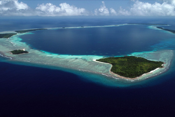 Plane view of the Chagos Archipelago, highlighting its vibrant blue lagoons and scattered islands in a tropical setting